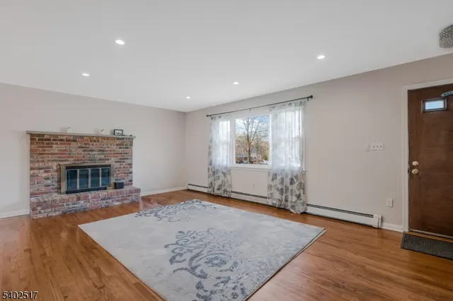 an empty room with wooden floor and fireplace