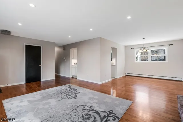 a view of a big room with wooden floor and windows