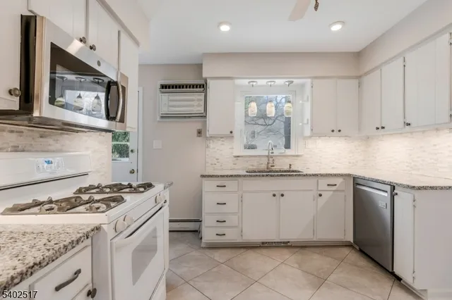 a kitchen with granite countertop cabinets and white appliances