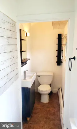 a bathroom with a toilet a sink and mirror