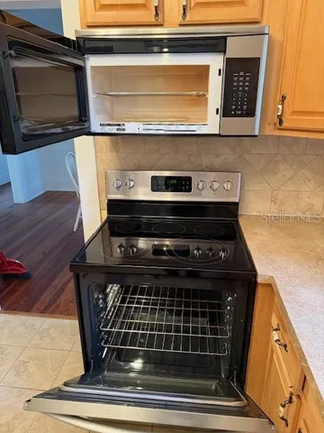 a stove top oven sitting inside of a kitchen