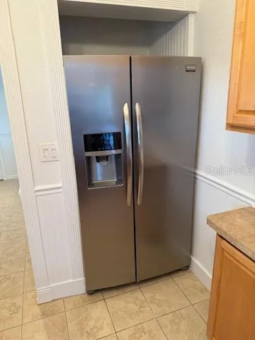 a metallic refrigerator freezer sitting in a kitchen