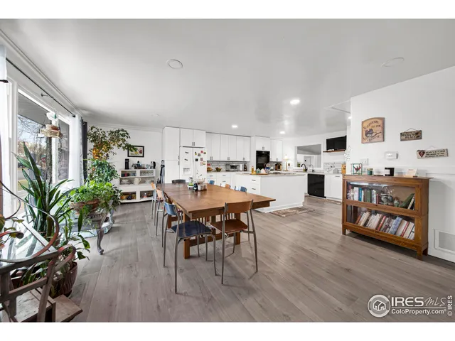 a living room with furniture and a dining table with wooden floor