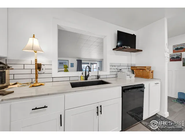 a kitchen with a sink and a stove top oven with wooden floor