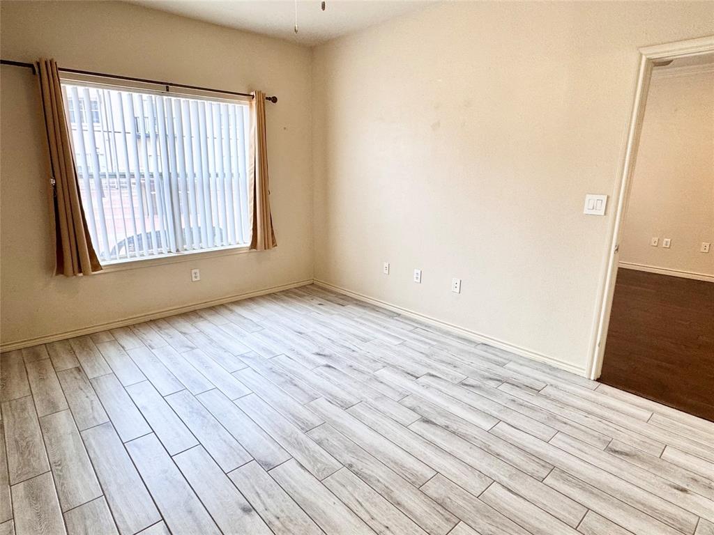 3102 Kings Road, Unit 2106 Dallas, TX 75219 - Photo 12 of 20 an empty room with wooden floor and windows