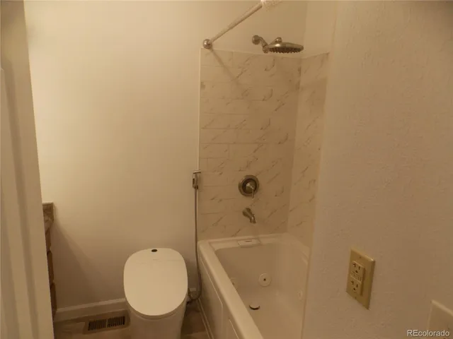 a bathroom with a granite countertop toilet a sink and shower