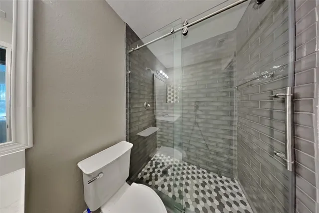a bathroom with a toilet and a shower