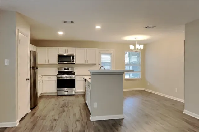 a kitchen with stainless steel appliances a refrigerator and a stove top oven