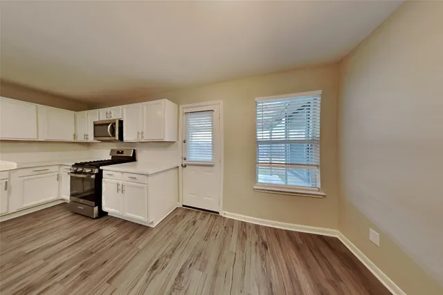 a kitchen with wooden floors and white appliances