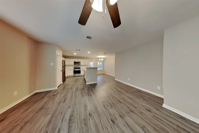 a view of empty room with wooden floor