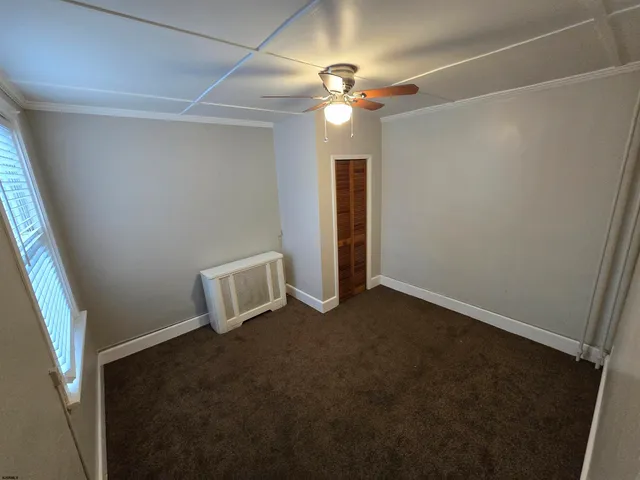 en empty room with windows and ceiling fan