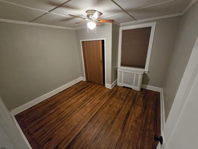 a view of room with wooden floor and fan