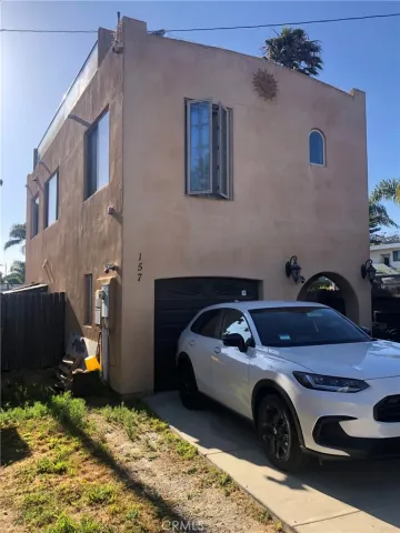 a front view of a house with a garden and trees