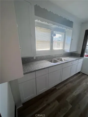 a bathroom with a granite countertop sink a toilet a mirror and vanity