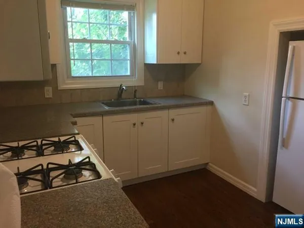 a kitchen with a sink a stove and cabinets