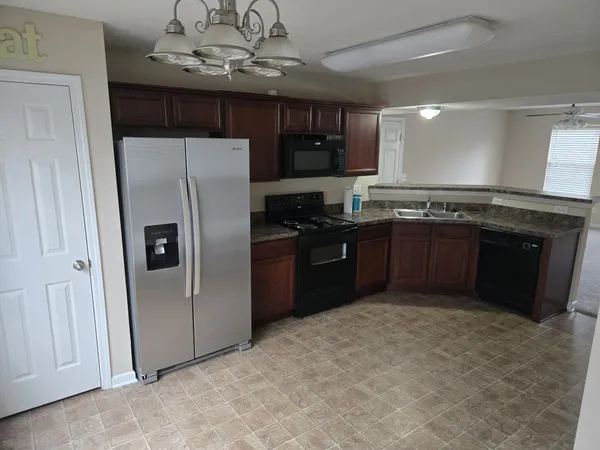 a kitchen with stainless steel appliances granite countertop a refrigerator and a sink