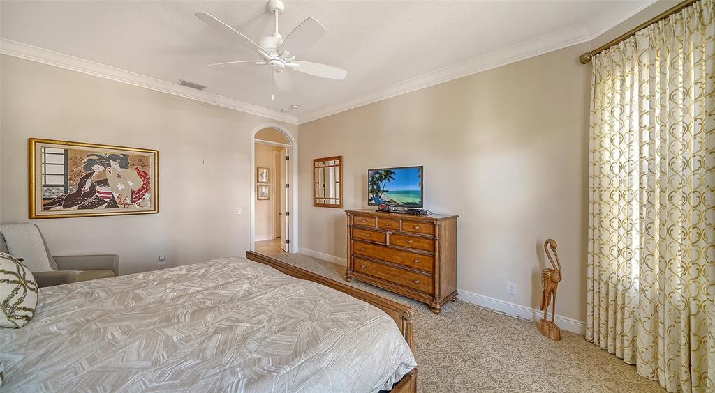 1005 Bogey Lane Longboat Key, FL 34228 - Photo 27 of 69 a bedroom with a bed and a chandelier