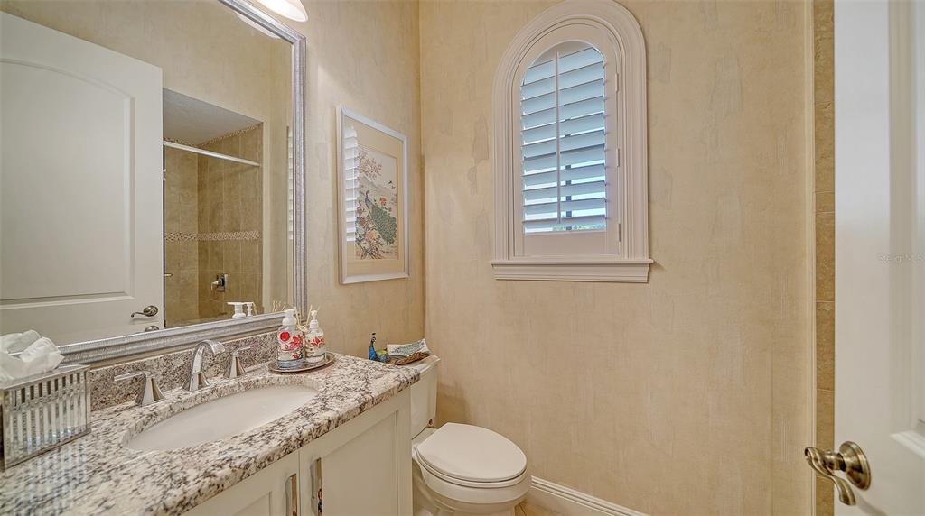 1005 Bogey Lane Longboat Key, FL 34228 - Photo 33 of 69 a bathroom with a granite countertop sink a toilet and a mirror