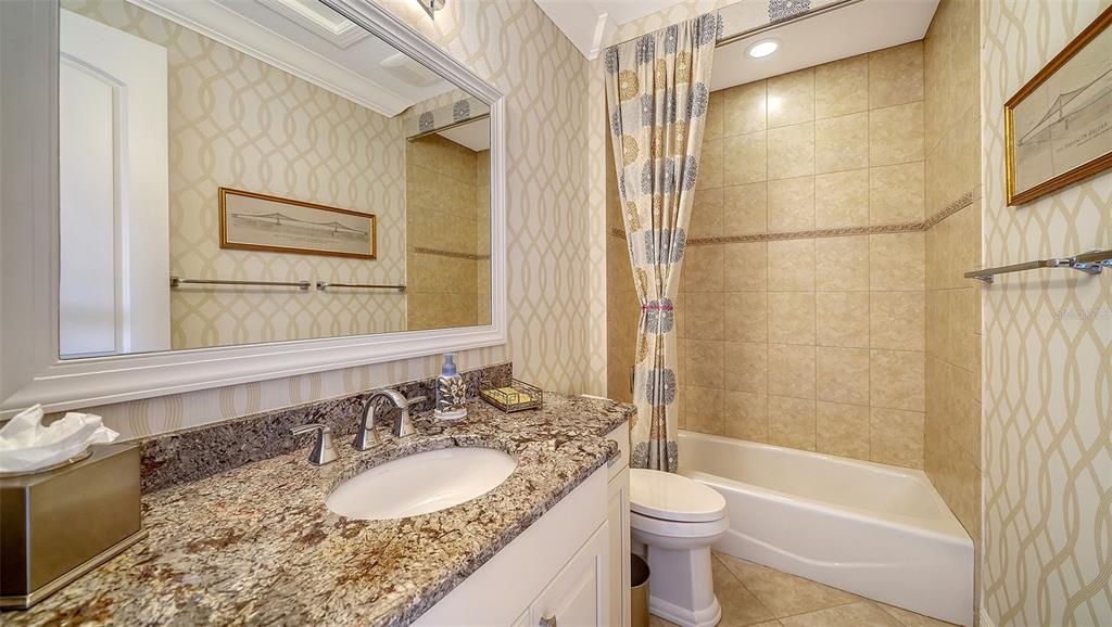 1005 Bogey Lane Longboat Key, FL 34228 - Photo 38 of 69 a bathroom with a granite countertop sink toilet and shower