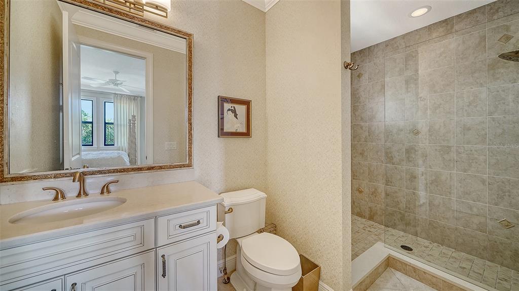 1005 Bogey Lane Longboat Key, FL 34228 - Photo 44 of 69 a bathroom with a granite countertop sink toilet and shower