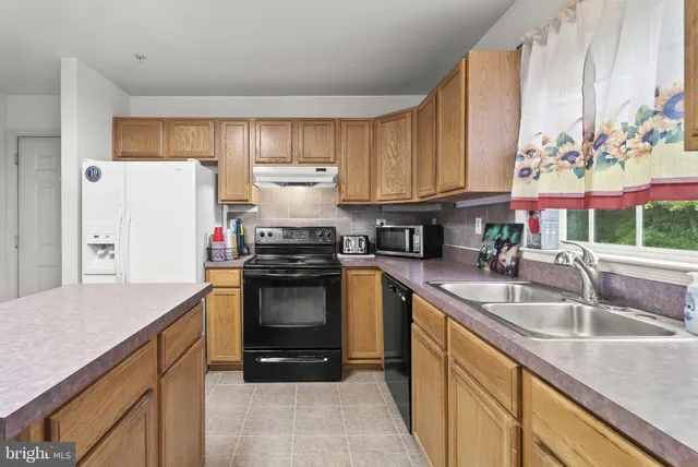 a kitchen with a sink stove and refrigerator