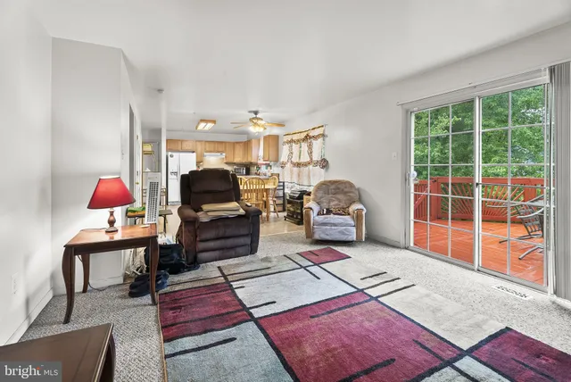 a living room with furniture a rug and a floor to ceiling window