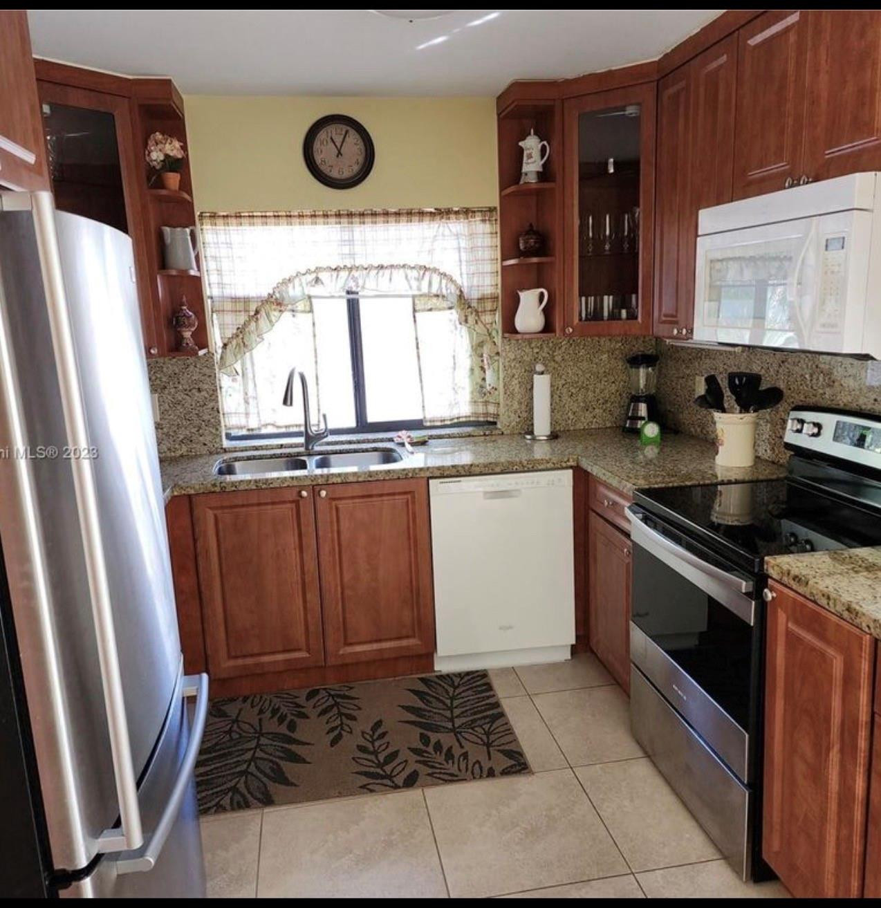 2925 Azalea Drive Hollywood, FL 33026 - Photo 12 of 13 a kitchen with a sink a stove and cabinets