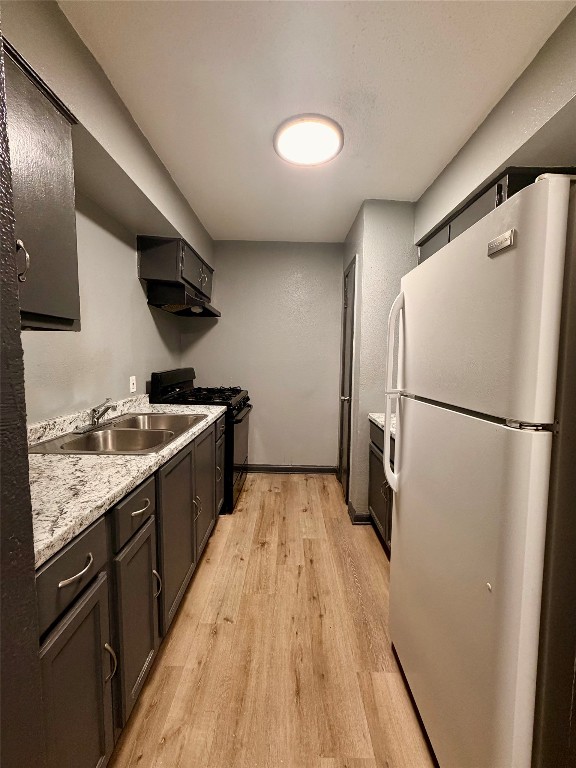 9100 Dodson Street, Unit 19 Houston, TX 77093 - Photo 5 of 16 a kitchen with granite countertop a refrigerator a sink and wooden floor