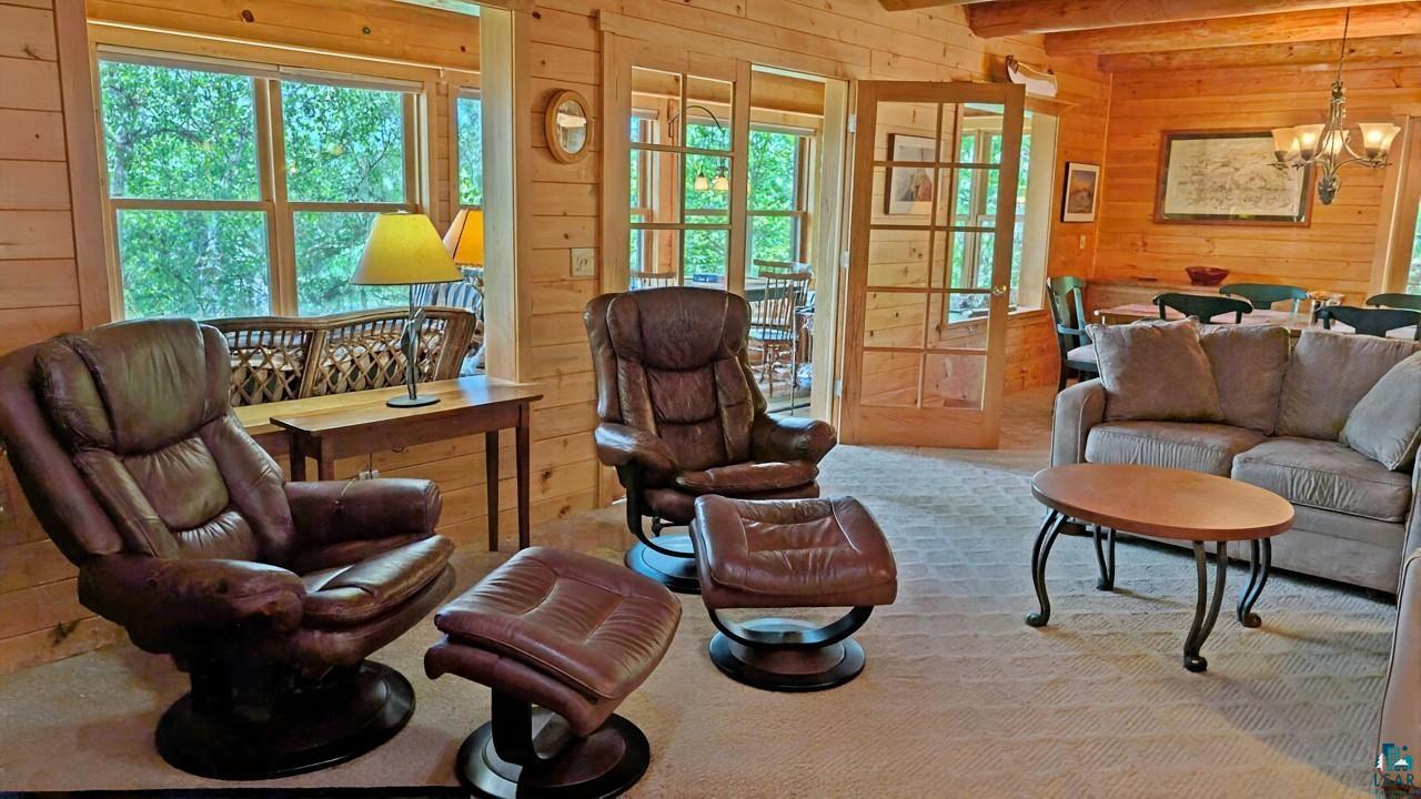 2357 Retreat Lodge Road Cook, MN 55723 - Photo 5 of 60 Living area featuring wood walls, ceiling fan, and a chandelier