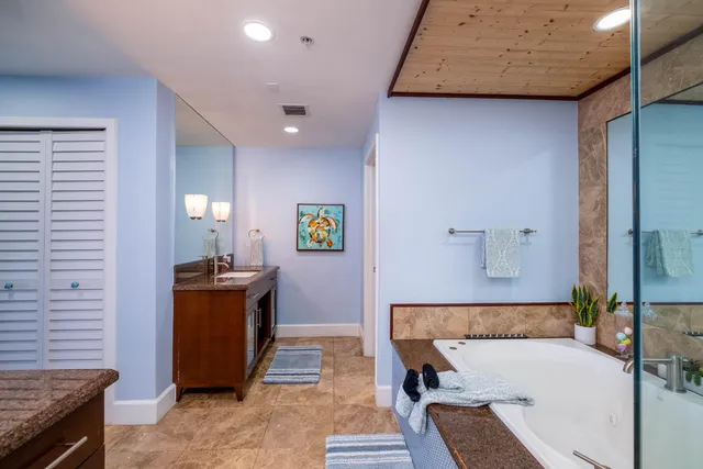 a bathroom with a granite countertop sink toilet mirror and shower