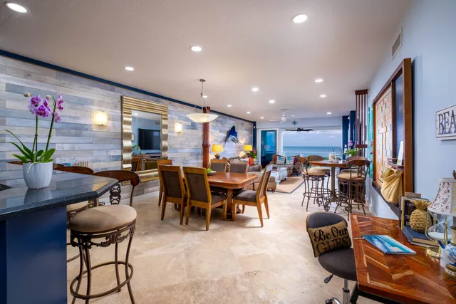 a dining room filled chandelier and kitchen view