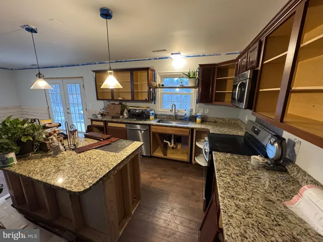 a kitchen filled with stainless steel appliances kitchen island granite countertop a stove and a refrigerator