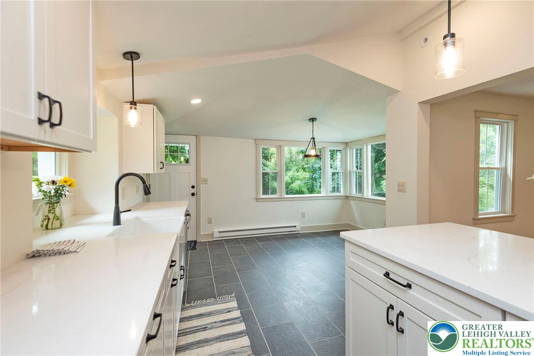 72 Allegheny Road Mount Bethel, PA 18343 - Photo 12 of 72 A well-lit kitchen with sleek white countertops and contemporary pendant lighting opens to a sun-filled dining area with ample natural views.