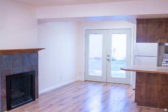 1269 North 400 East, Unit 3 Logan, UT 84341 - Photo 8 of 23 Living area featuring wood-finish flooring and a tiled fireplace with a wood mantel