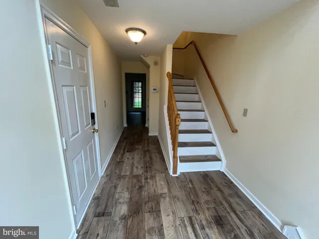 a view of a hallway with wooden floor and entryway