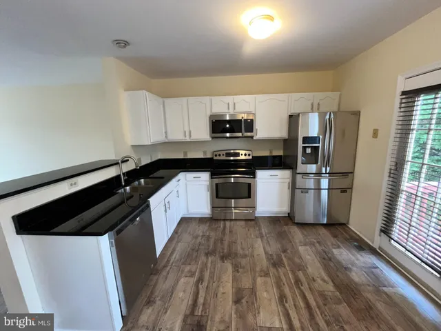 a kitchen with a refrigerator a stove top oven and a sink
