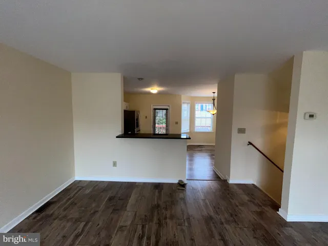 a view of a living room with wooden floor and a window