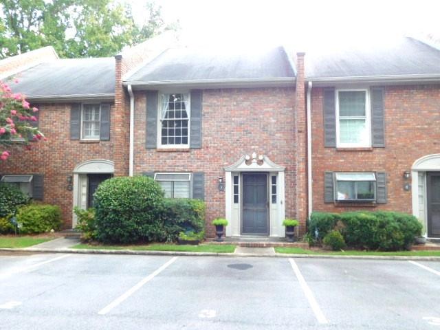 a front view of a house with a garden and plants