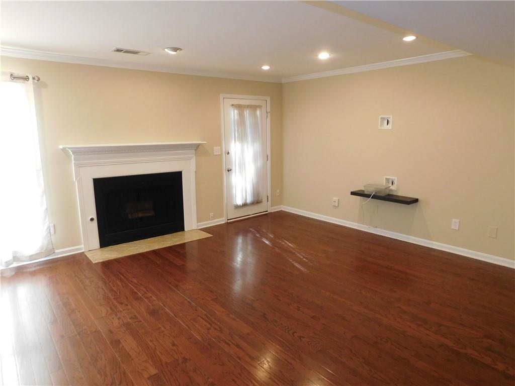 1245 South Ponce De Leon Avenue Northeast, Unit C2 Atlanta, GA 30306 - Photo 14 of 27 an empty room with wooden floor and fireplace