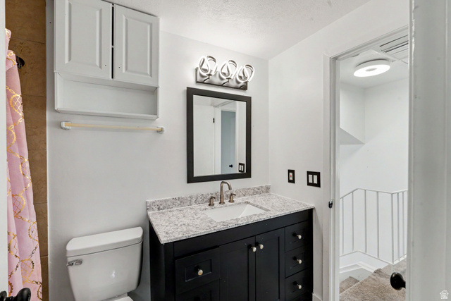 3689 Lasso Loop Circle Magna, UT 84044 - Photo 12 of 26 1st Bathroom upstairs vanity featuring a dark wood-finish base, integrated rectangular sink, and light-toned speckled countertop