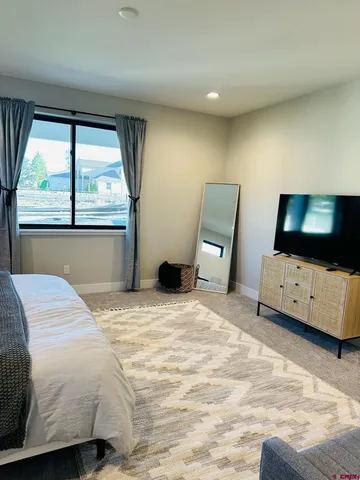 a bedroom with a bed and large windows