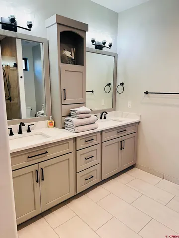 a spacious bathroom with a double vanity sink and mirror