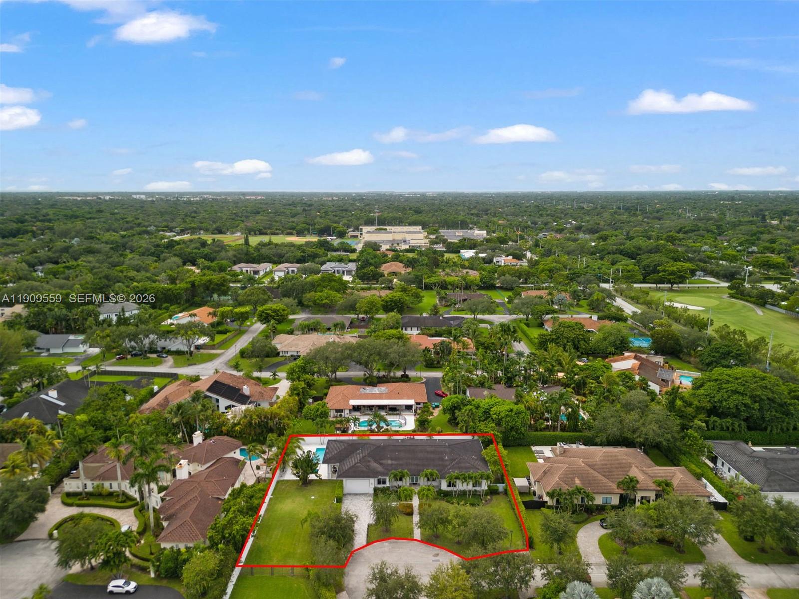 an aerial view of residential houses with outdoor space and trees