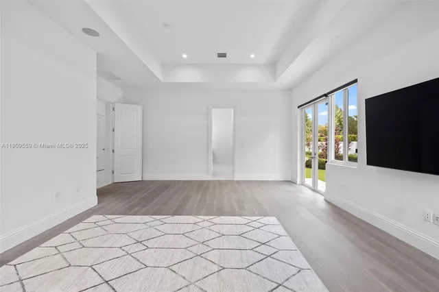 a view of a hallway with wooden floor and a chandelier