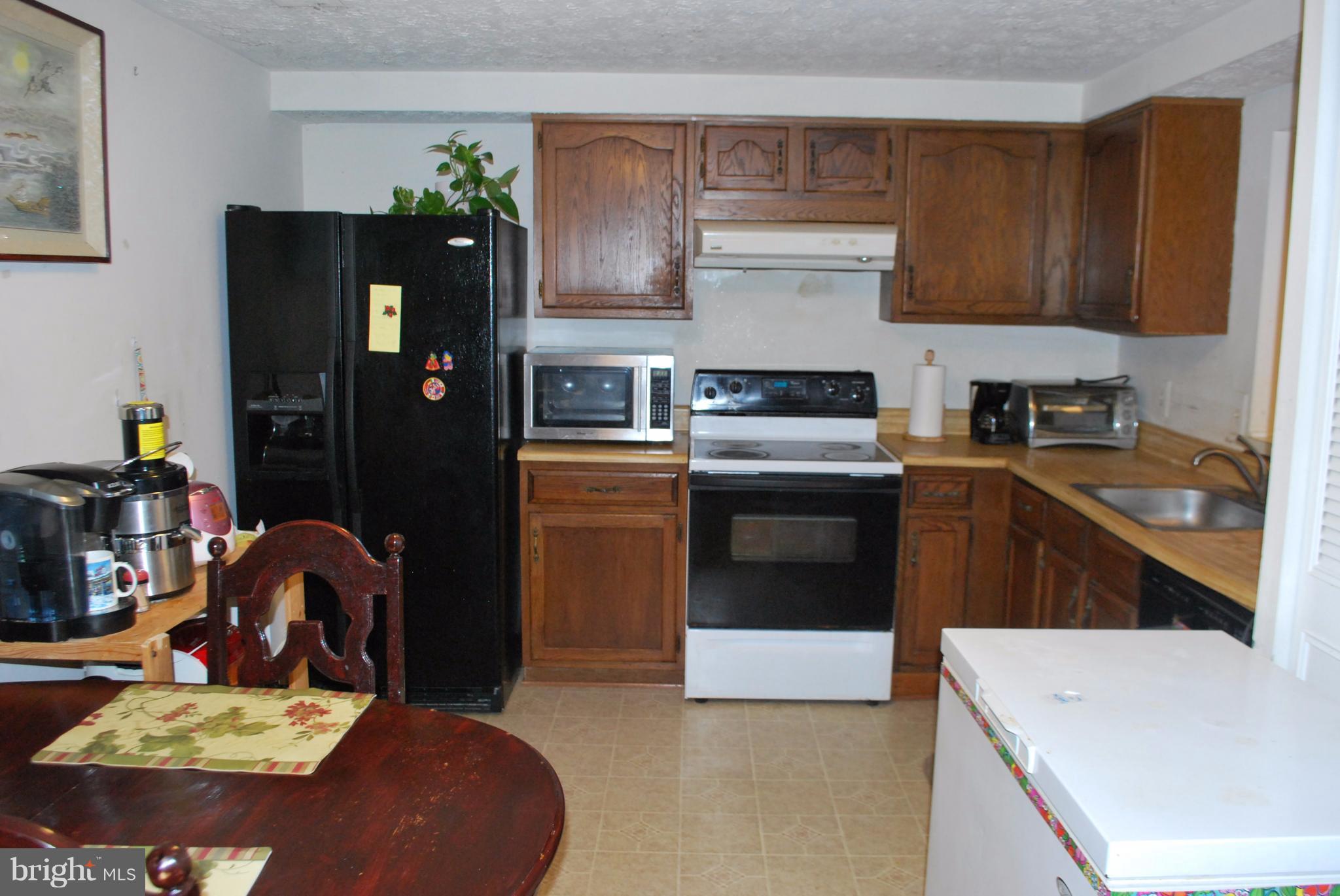 6900 Villa-Del-Rey Court Springfield, VA 22150 - Photo 8 of 29 a kitchen with stainless steel appliances sink stove refrigerator and cabinets