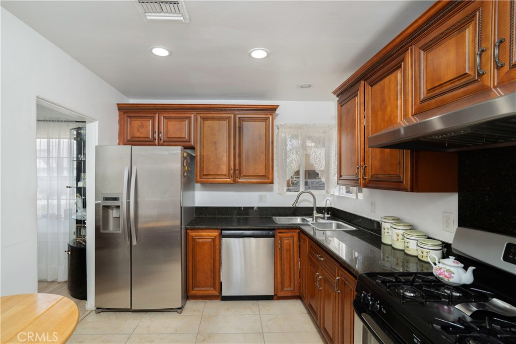 1020 Allen Avenue Glendale, CA 91201 - Photo 2 of 16 a kitchen with stainless steel appliances granite countertop a refrigerator a sink a stove and wooden cabinets