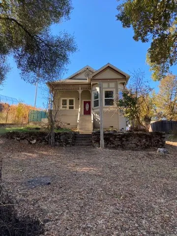 a front view of a house with a yard and trees