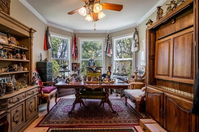 a living room with furniture a bookshelf and a window