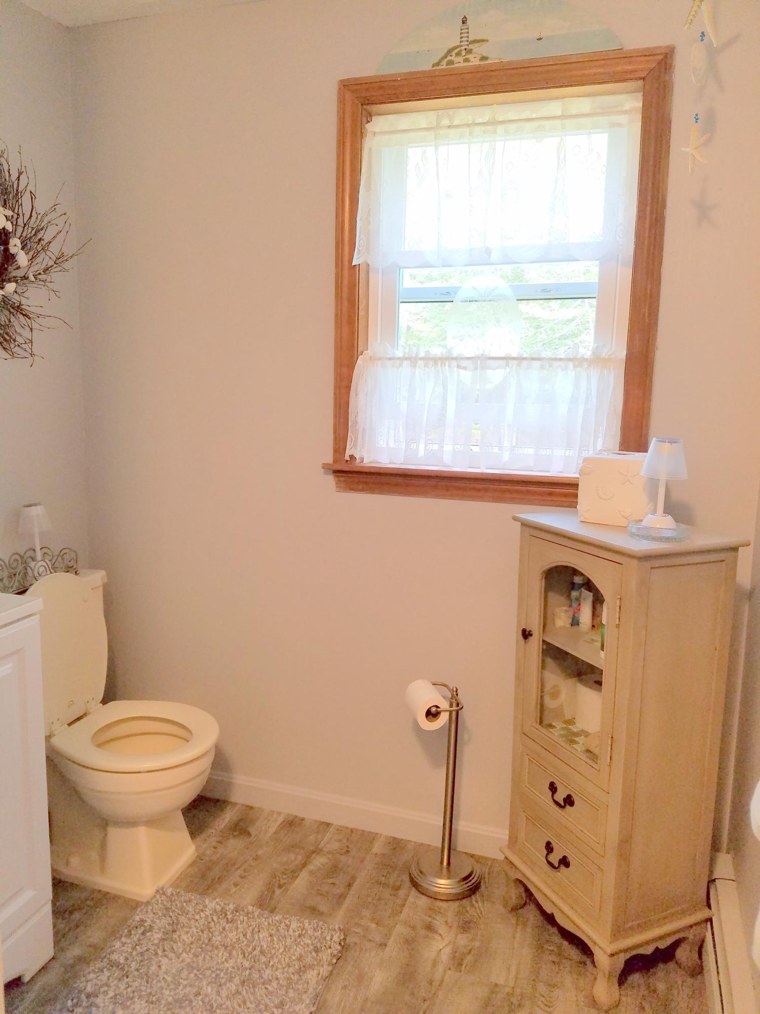 835 Cotuit Road Mashpee, MA 02649 - Photo 12 of 14 a bathroom with a toilet a sink a window and mirror