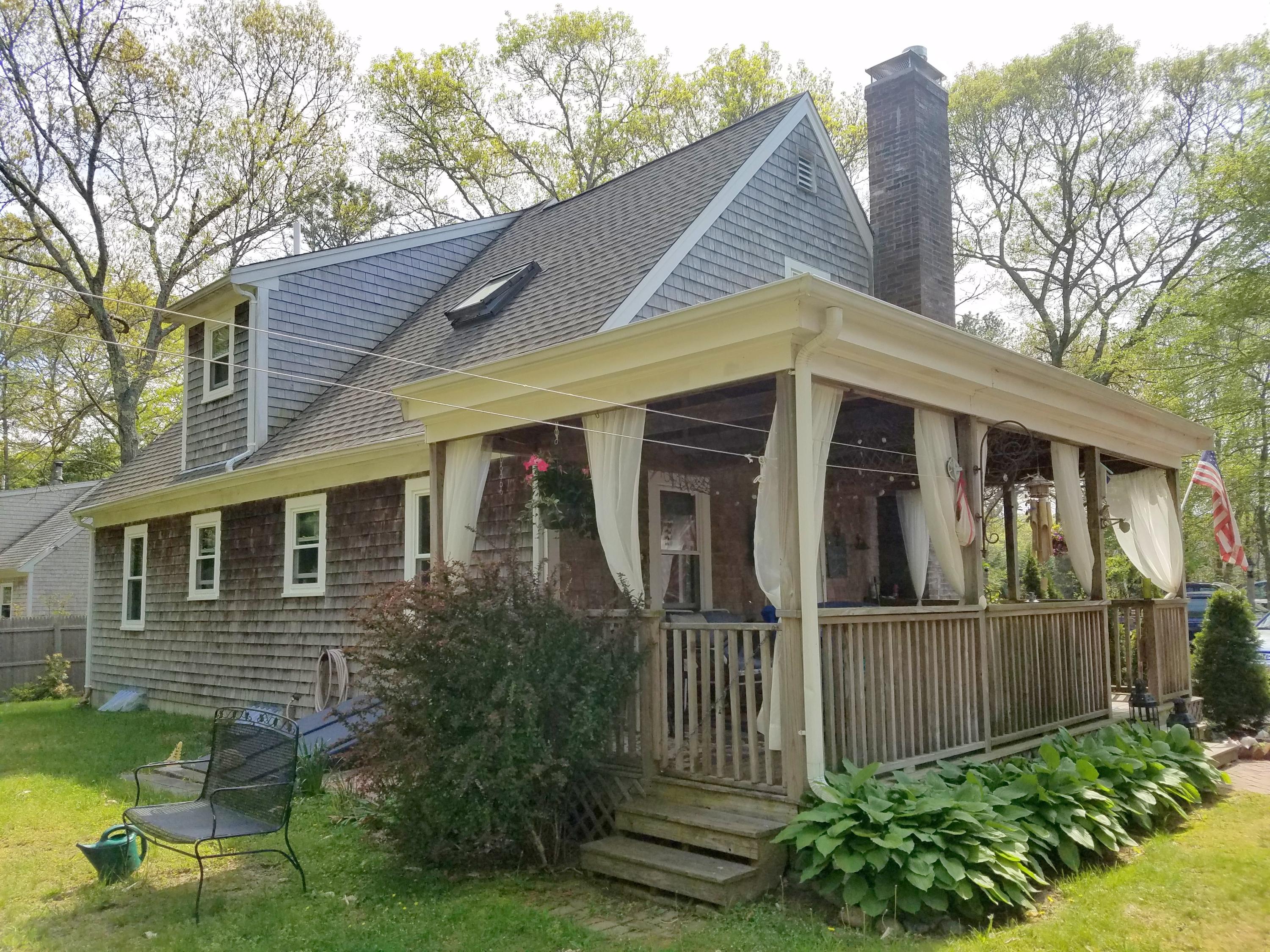 835 Cotuit Road Mashpee, MA 02649 - Photo 6 of 14 a view of a house with a yard and furniture